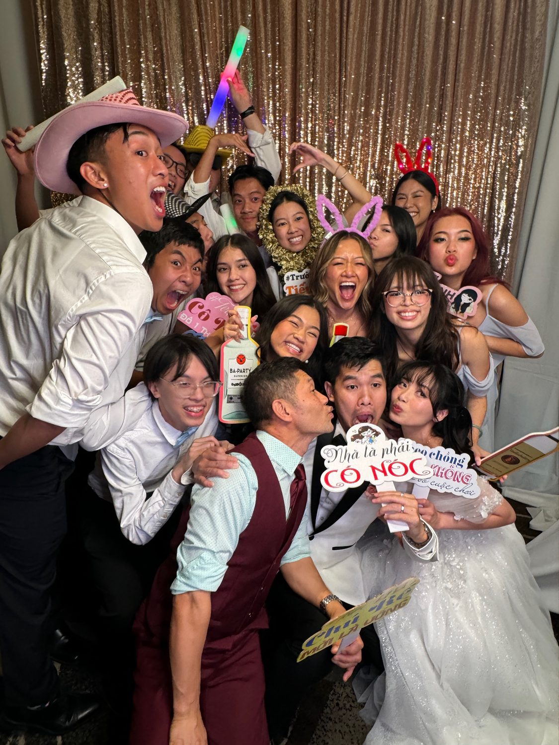 Wedding guests crowding the photo booth with props