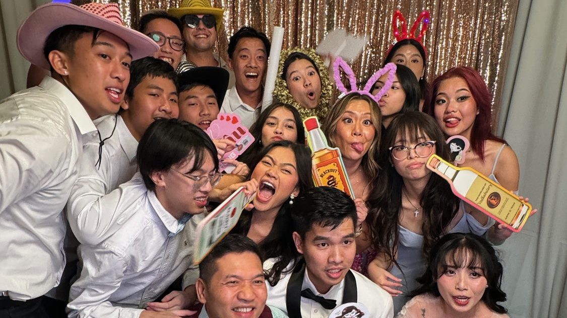 Guests packed into a Dynamic Celebrations photo booth with props