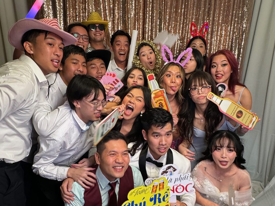 Guests packed into a Dynamic Celebrations photo booth with props