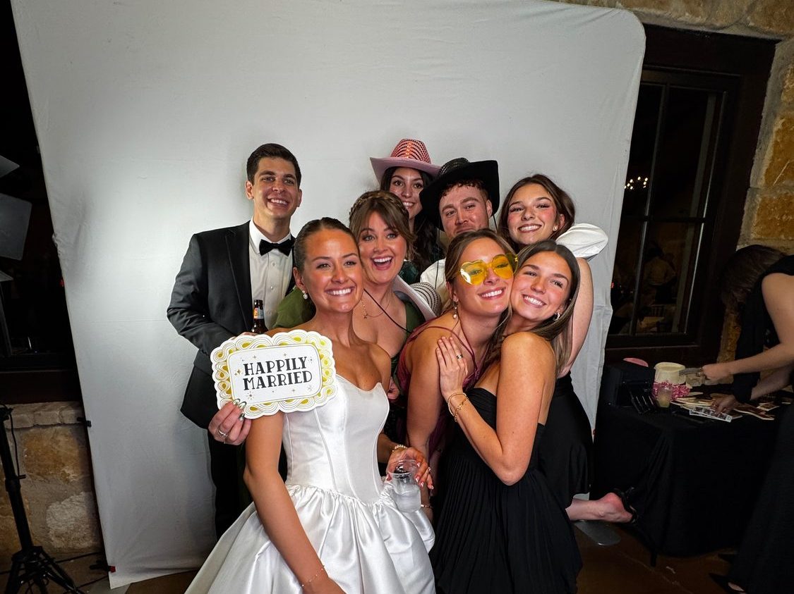 Guests at the Glam photo booth with studio lighting and props