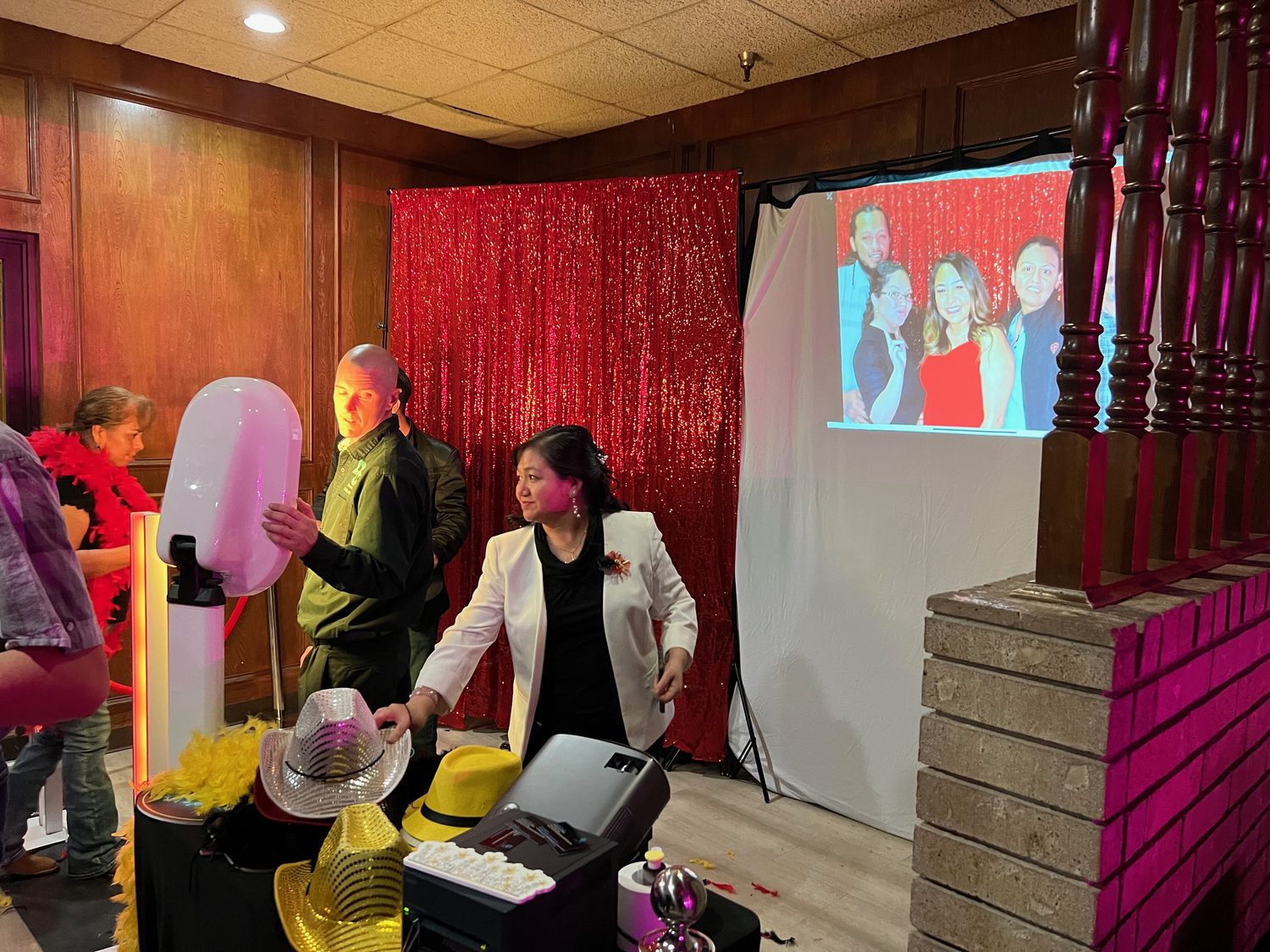 Photo booth and prop table set up against a red sequin backdrop