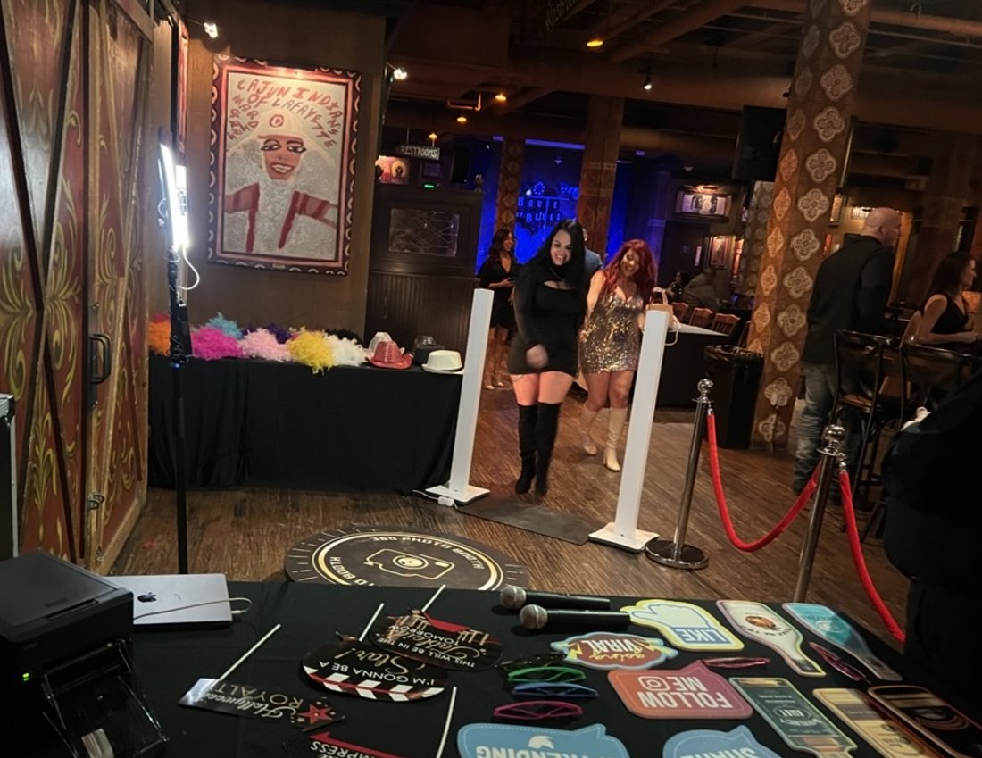 The Dynamic Celebrations 360 photo booth set up with props and prints at an event