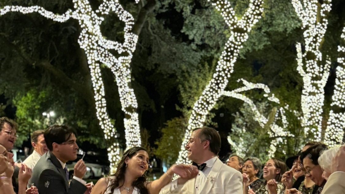 The couple dancing surrounded by their guests