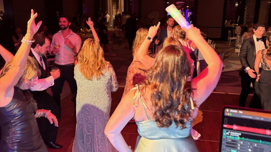 Guests dancing under coloured uplighting