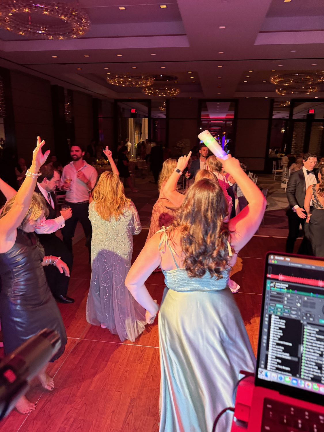 Guests dancing under coloured uplighting